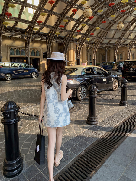 Light blue floral sleeveless mini dress worn by a model outdoors