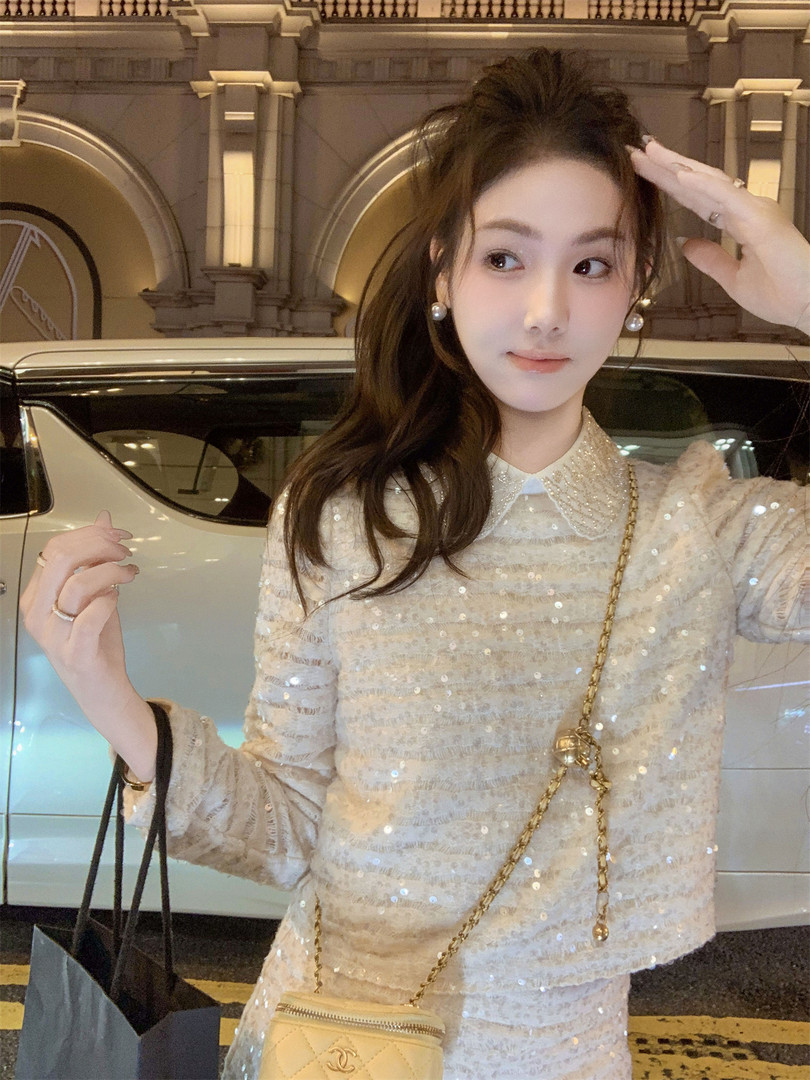 Woman wearing a sparkly cream sequin outfit with a gold chain bag