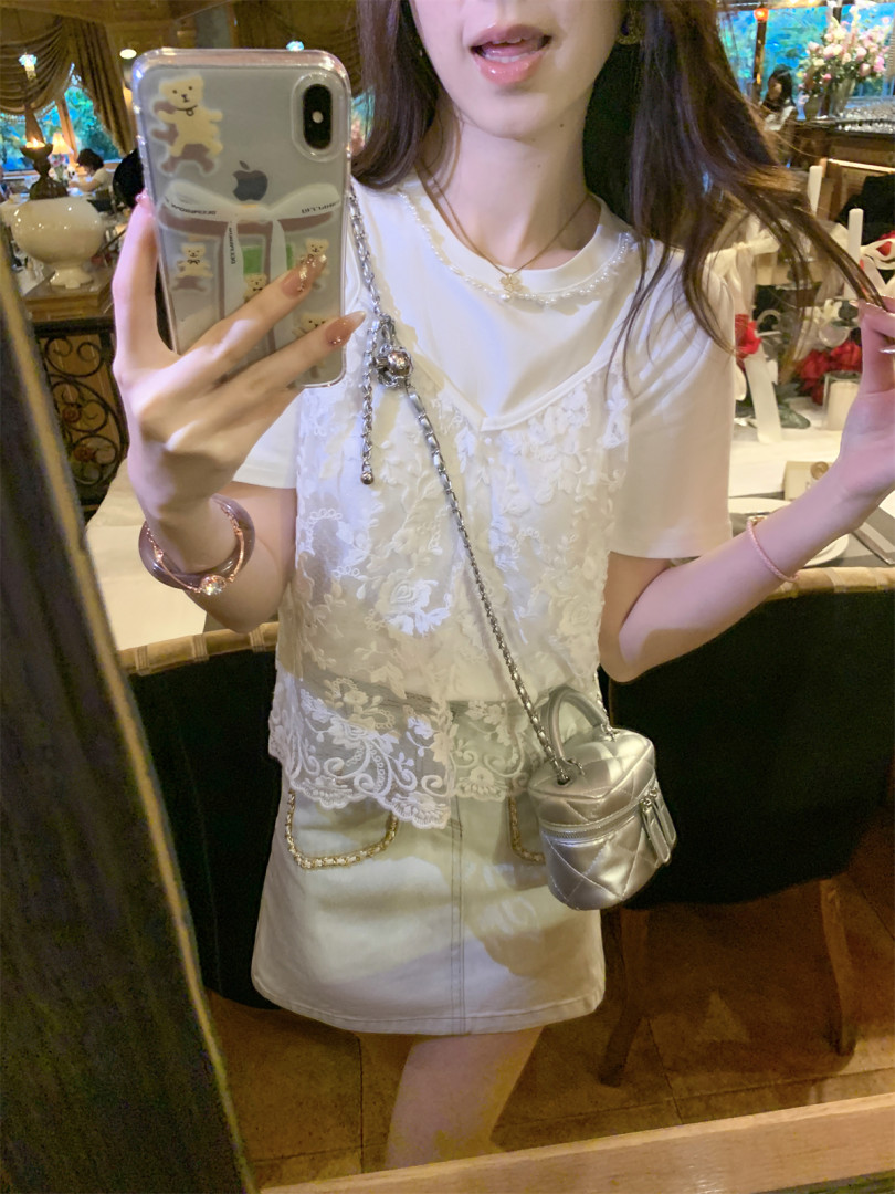 Woman wearing a white lace layered top with a silver chain mini bag and light skirt