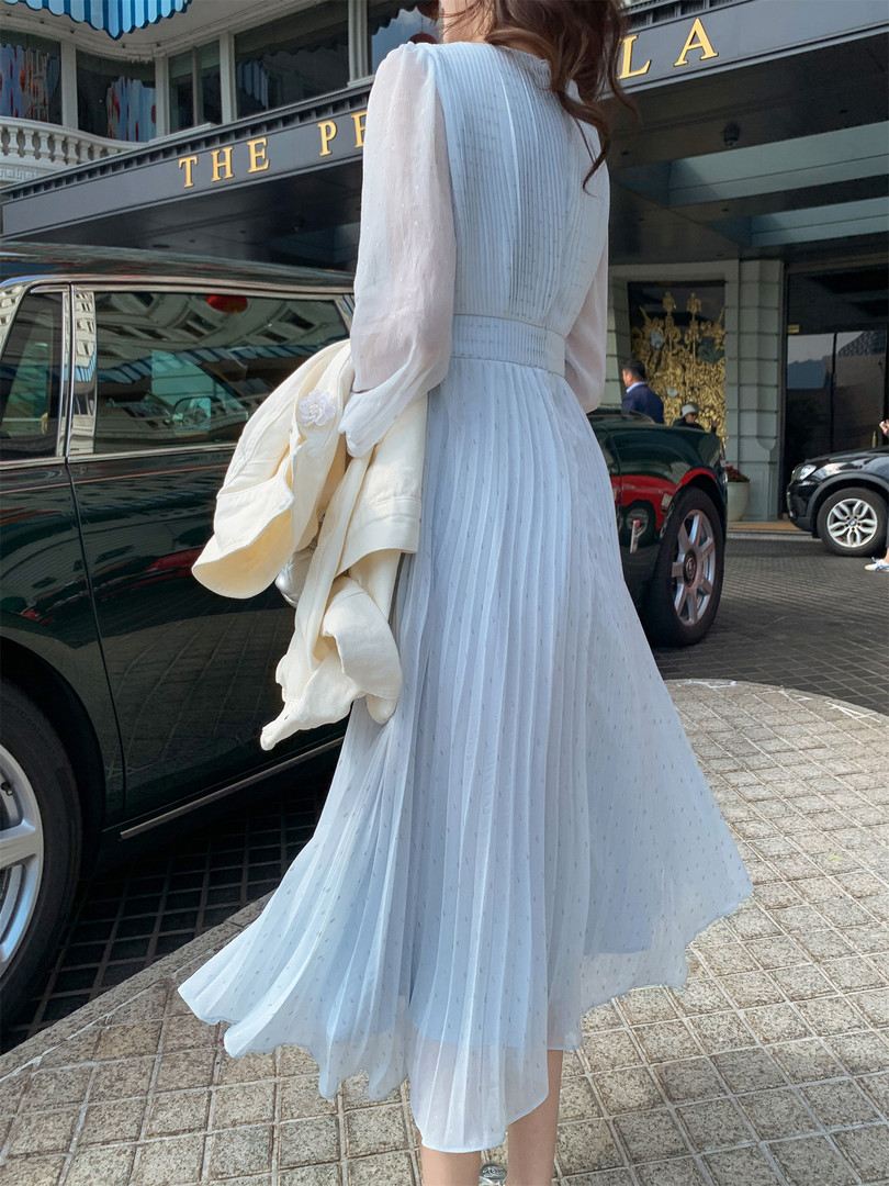 Woman wearing a white pleated midi dress outdoors