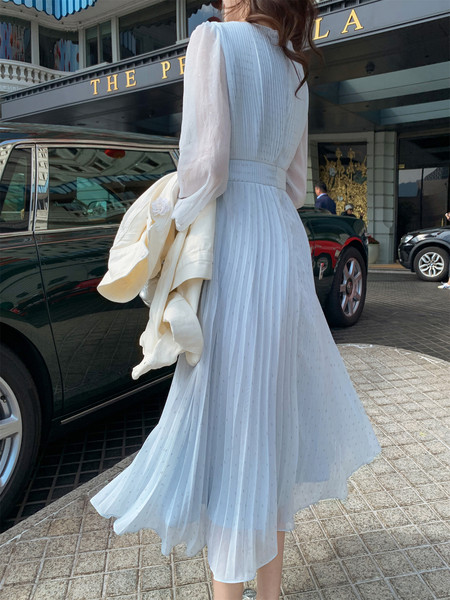 Woman wearing a white pleated midi dress outdoors