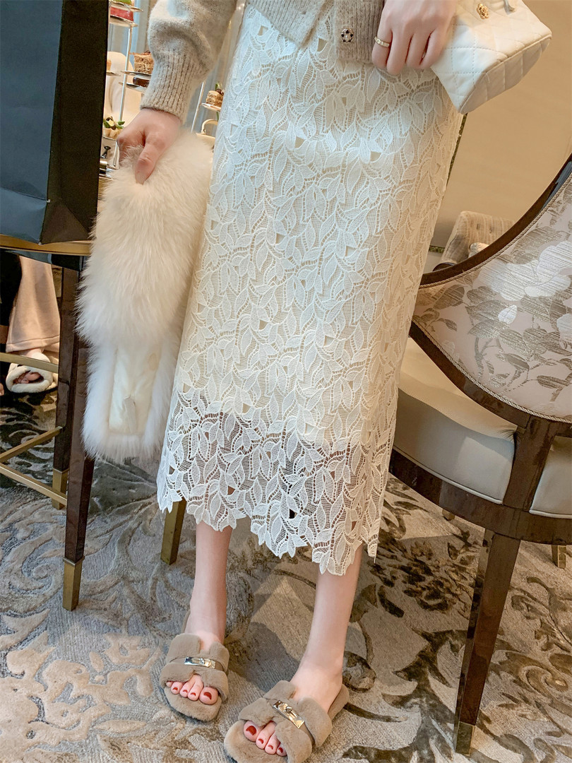 White lace midi dress worn with a clutch and fluffy slippers