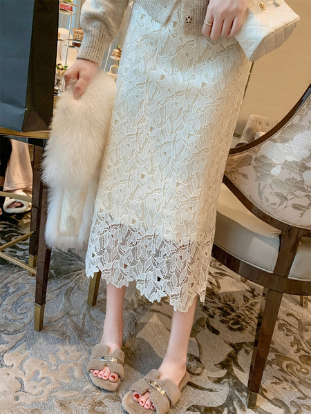 White lace midi dress worn with a clutch and fluffy slippers