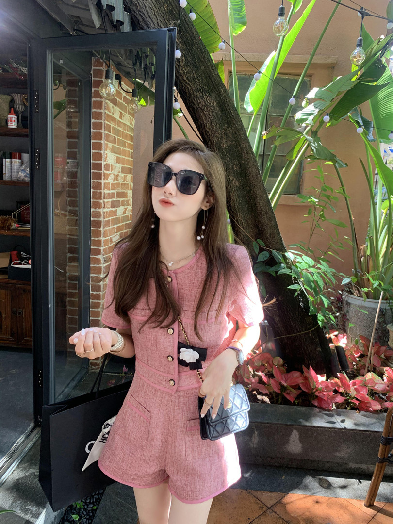 Pink textured short-sleeve two-piece outfit worn by a model outdoors