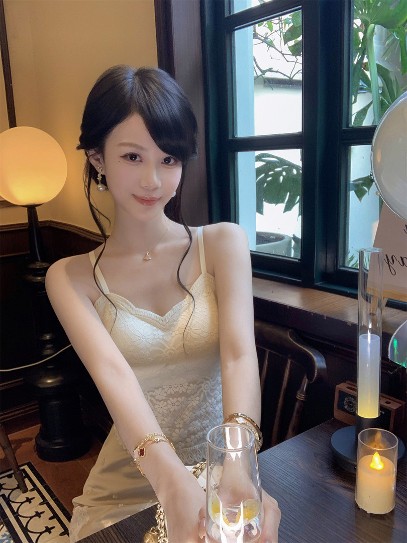 Woman wearing a cream lace spaghetti-strap dress