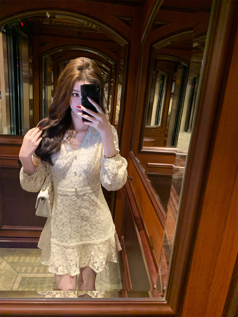 Woman wearing a cream lace long-sleeve dress in a mirror selfie