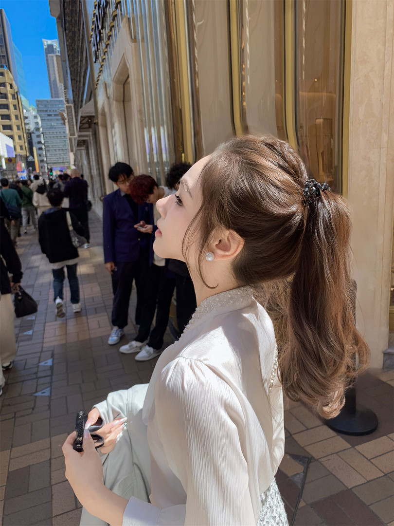 Woman wearing a white blouse outdoors on a city street