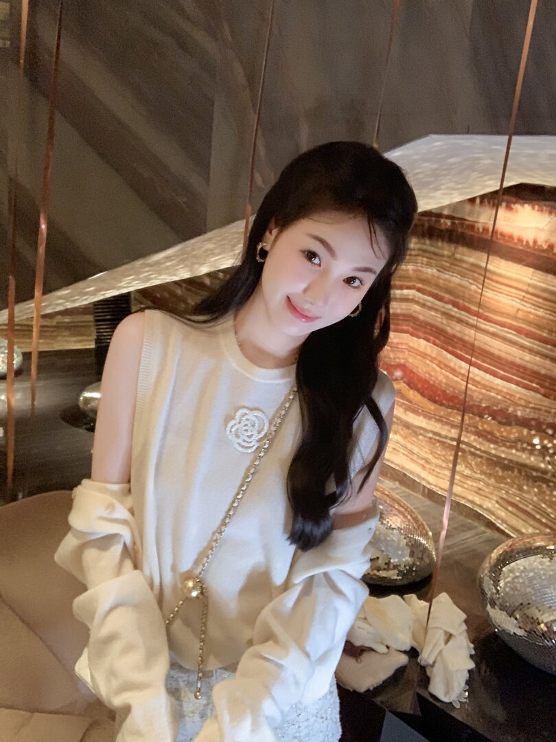 White sleeveless fashion top with decorative flower brooch worn by a model