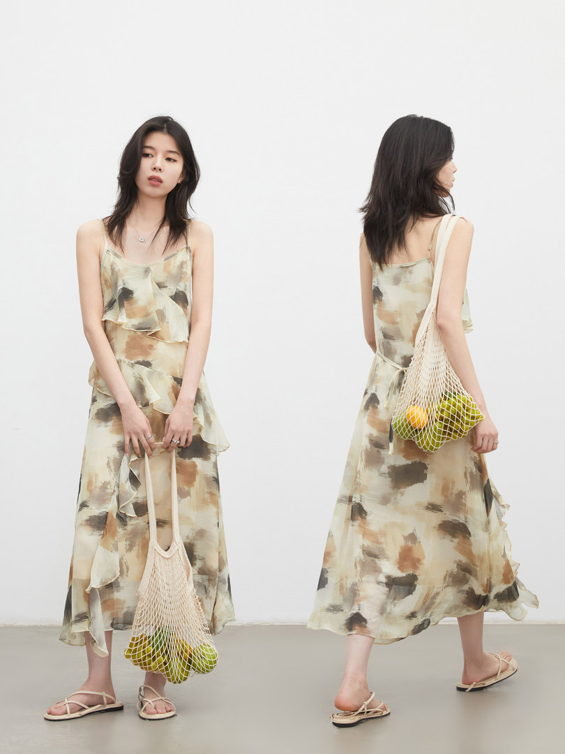 Model wearing a lightweight patterned sleeveless dress with ruffle details