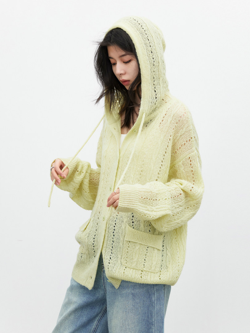 Model wearing a pale yellow hooded knit cardigan with pocket details