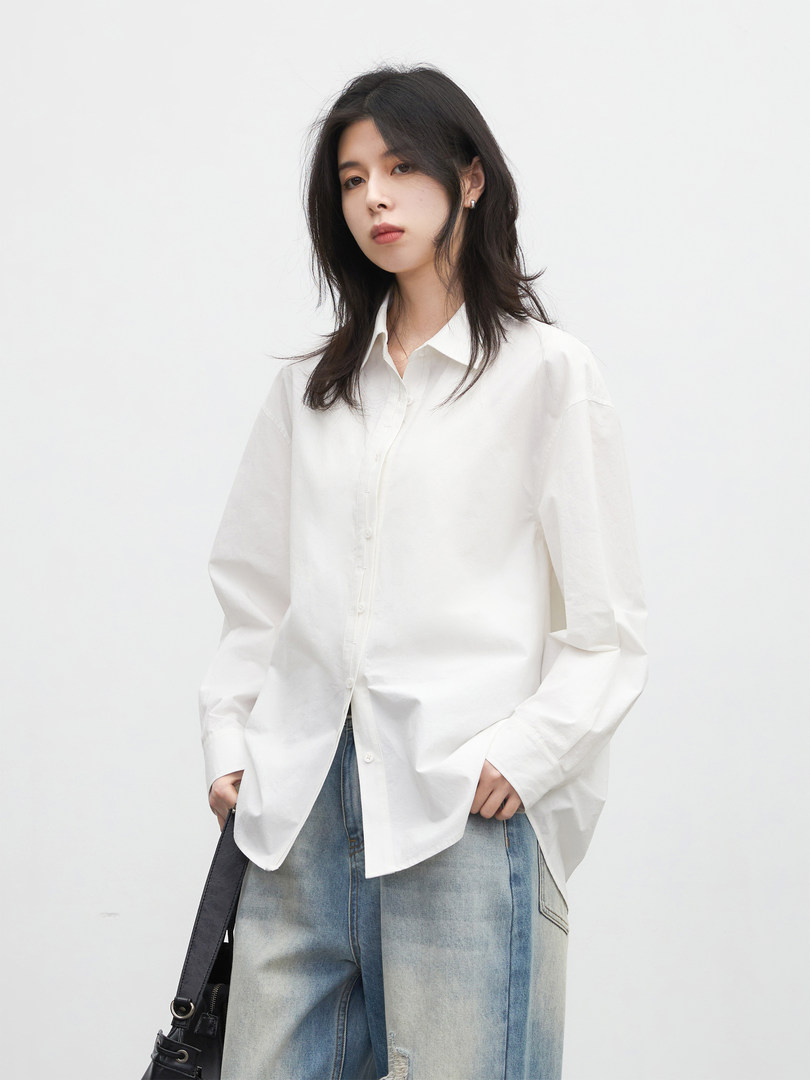 Model wearing a white button-up shirt with loose-fit jeans