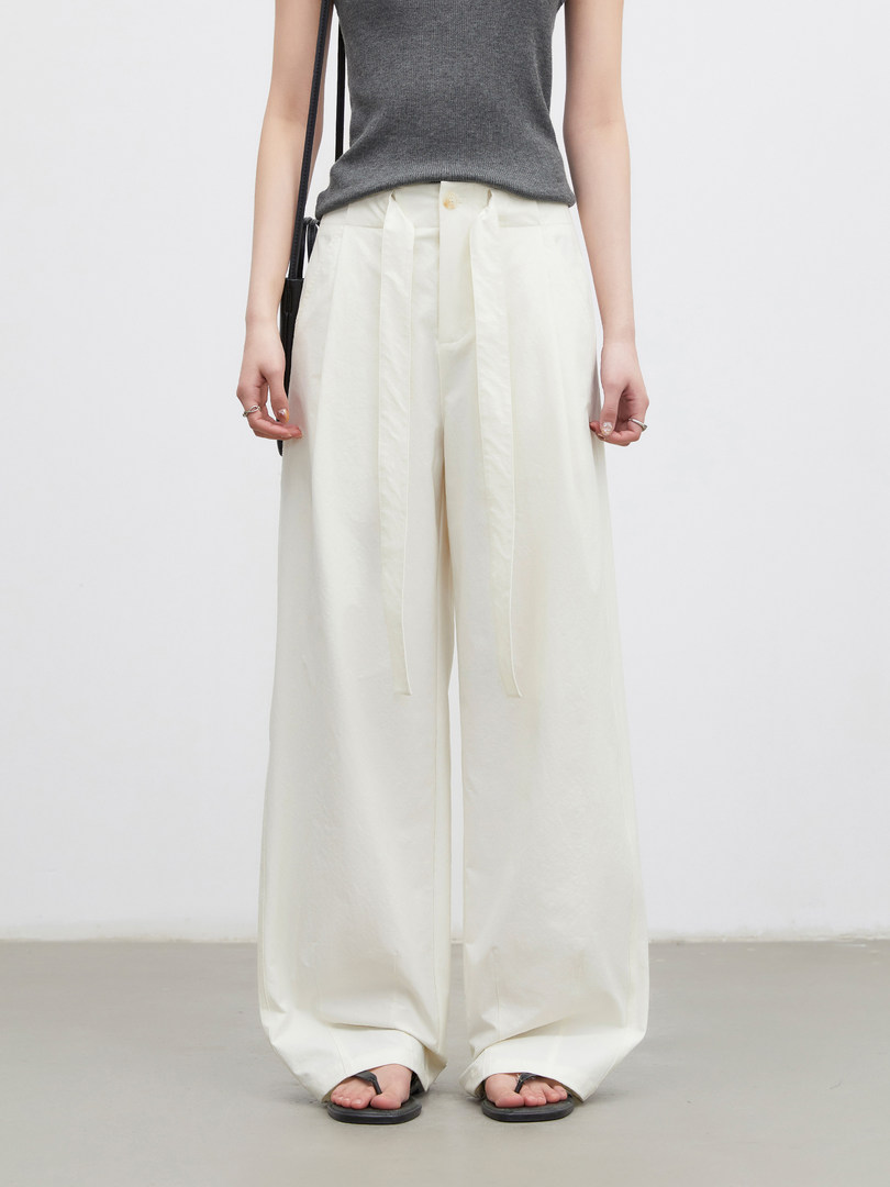 White wide-leg trousers worn with a gray sleeveless top and black sandals