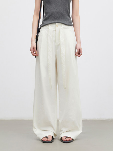 White wide-leg trousers worn with a gray sleeveless top and black sandals