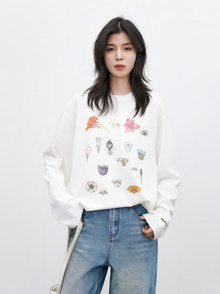 Model wearing a white floral graphic sweatshirt with blue jeans