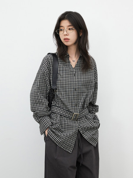 Model wearing a black-and-white checkered long-sleeve shirt with a belt