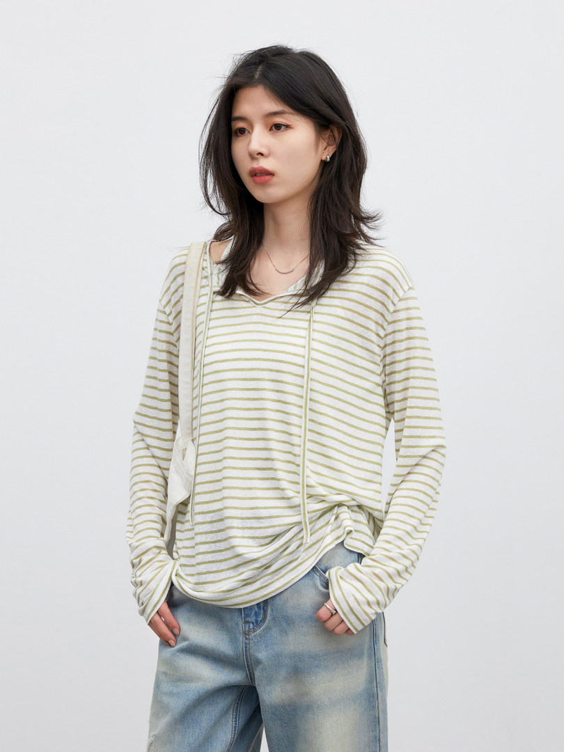 Model wearing a light striped long-sleeve top with loose blue jeans
