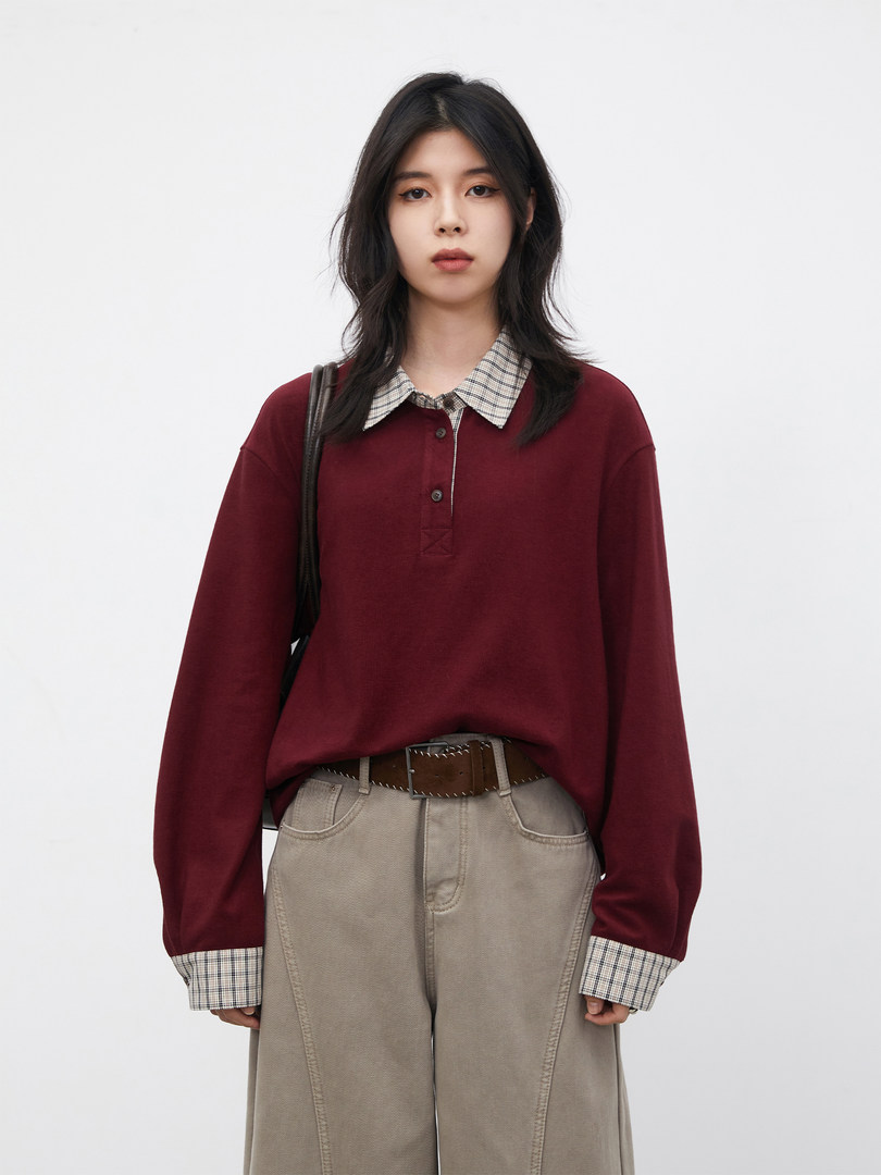 Model wearing a burgundy collared long-sleeve top with plaid trim and beige wide-leg pants