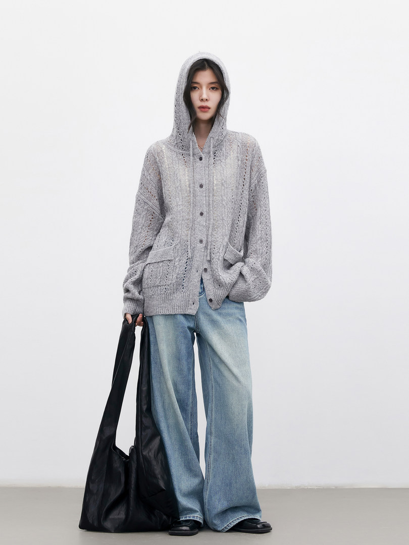 Model wearing a gray knit hooded cardigan with wide-leg jeans