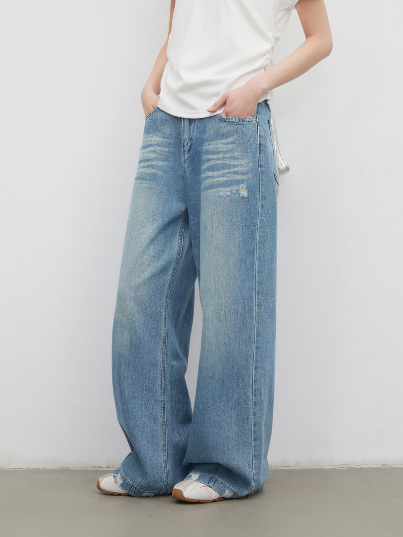 Wide-leg light blue distressed jeans worn with a white top