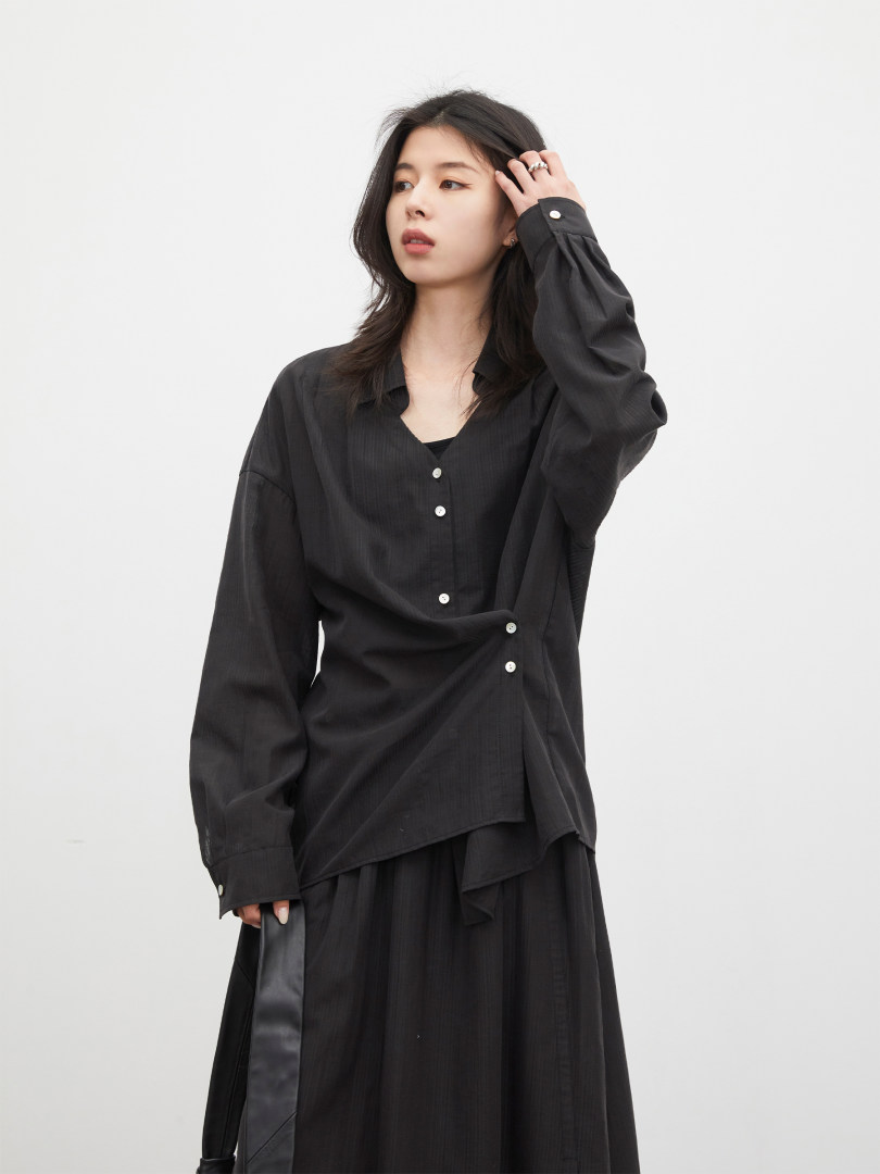 Black long-sleeve button-up shirt and matching skirt worn by a model