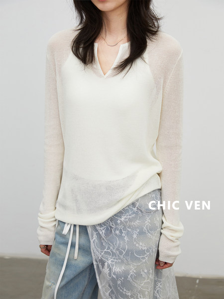 Model wearing a cream lightweight sheer long-sleeve top with layered blue lace-detail bottoms