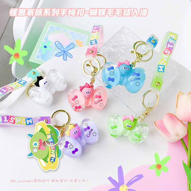 丑萌糖果色小怪兽蝴蝶结入油钥匙扣液体漂浮手绳挂件书包汽车礼物
