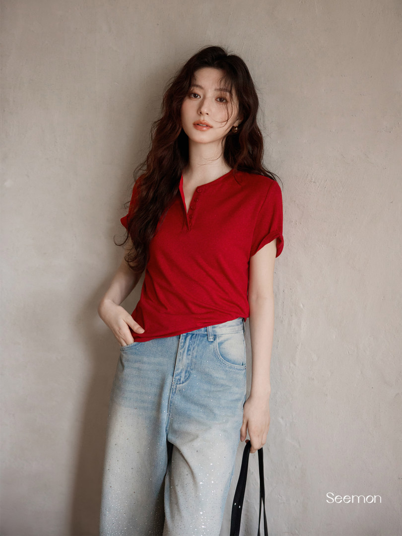 Model wearing a red short-sleeve top with light blue jeans