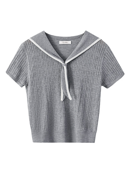 Model wearing a gray short-sleeve knit top with a sailor-style tie and black pleated skirt outdoors