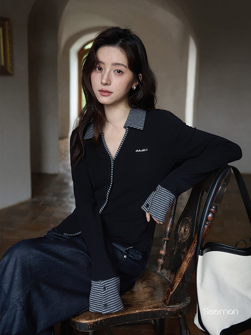 Woman modeling a black long-sleeve outfit with striped collar and cuffs