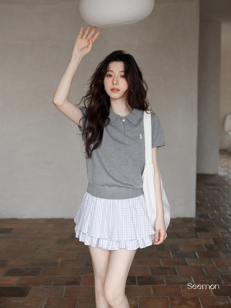 Model wearing a gray polo knit top with a white plaid ruffled mini skirt