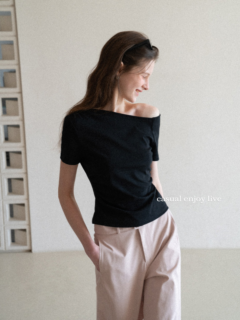 Woman wearing a black off-shoulder top with beige pants