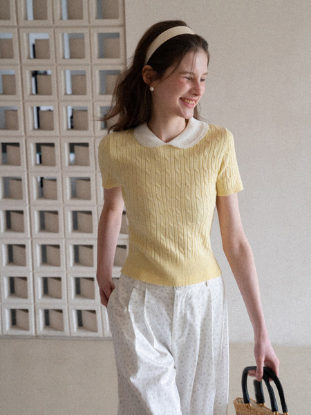 Woman wearing a yellow short-sleeve knit top with a white collar
