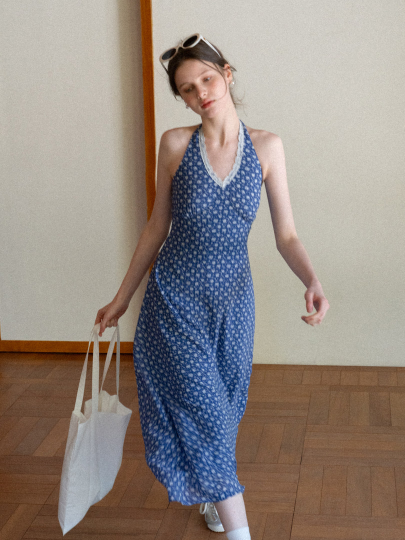 Model wearing a blue floral halter midi dress