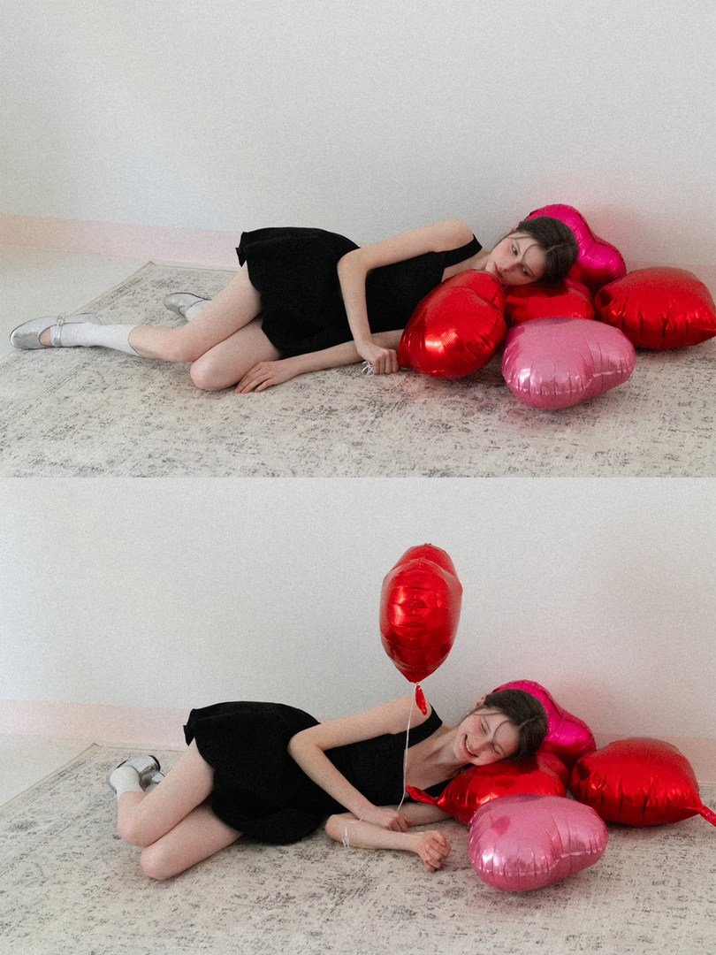 Black sleeveless dress worn by a model with heart-shaped balloons
