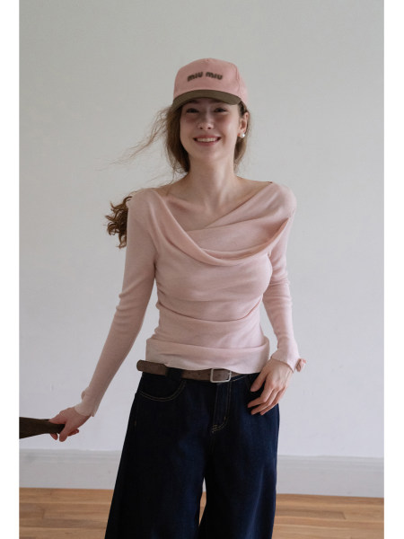 Woman wearing a pink off-shoulder top with a pink cap and dark jeans