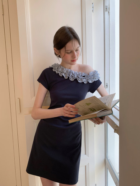 Woman wearing a navy off-shoulder ruffled mini dress