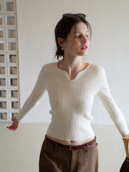 Cream cable-knit long-sleeve top worn by a model