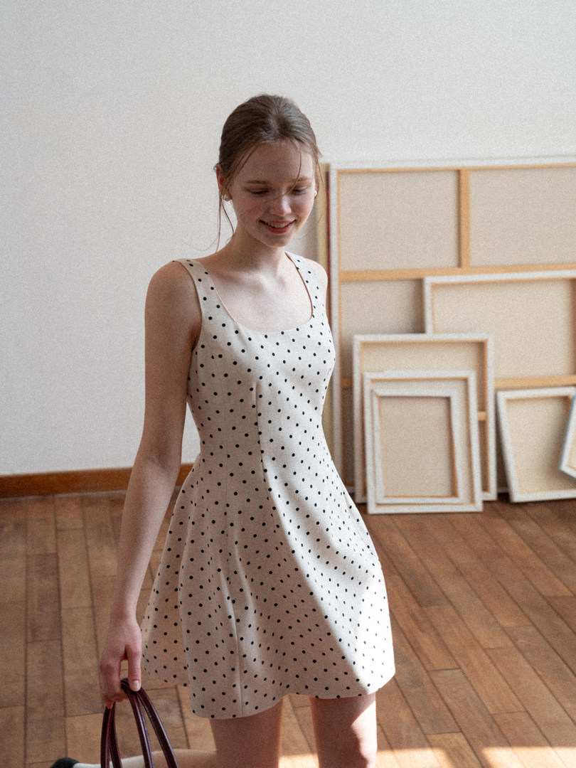 Woman wearing a white polka dot sleeveless dress