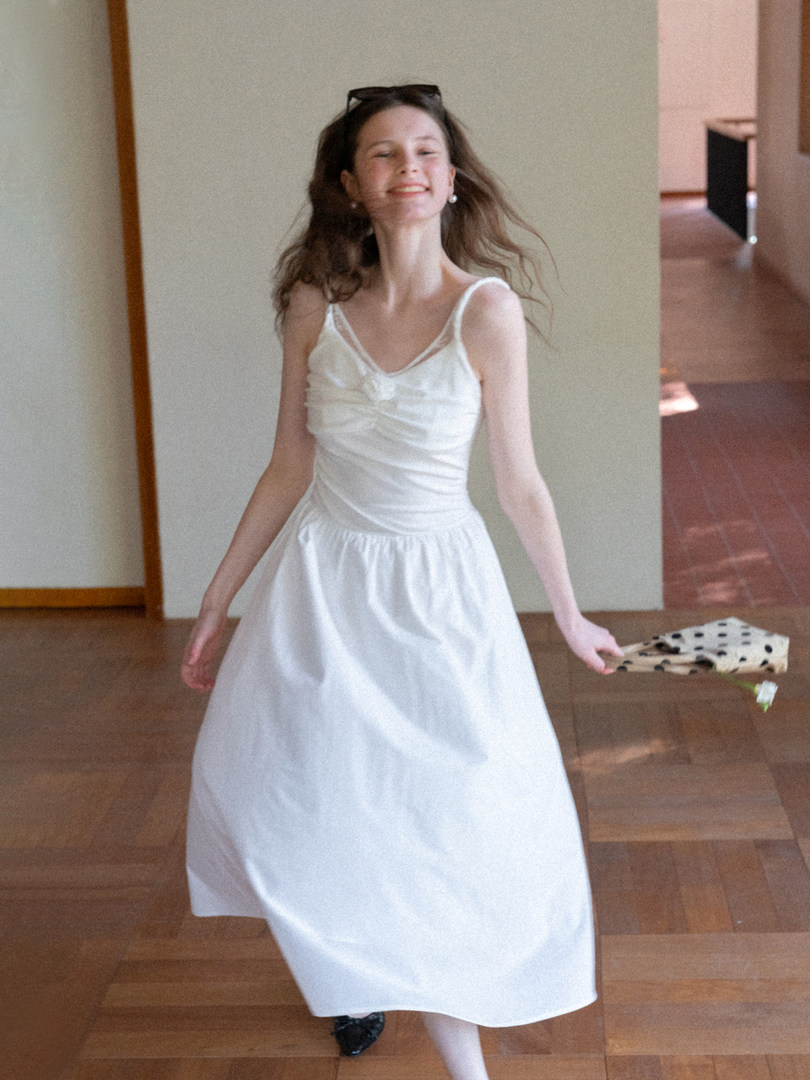 Woman wearing a white sleeveless midi dress indoors