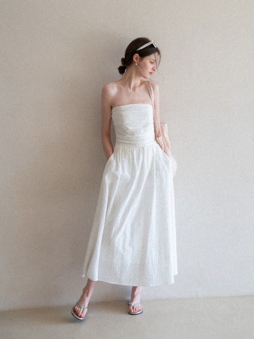 Woman wearing a white strapless midi dress with a relaxed silhouette