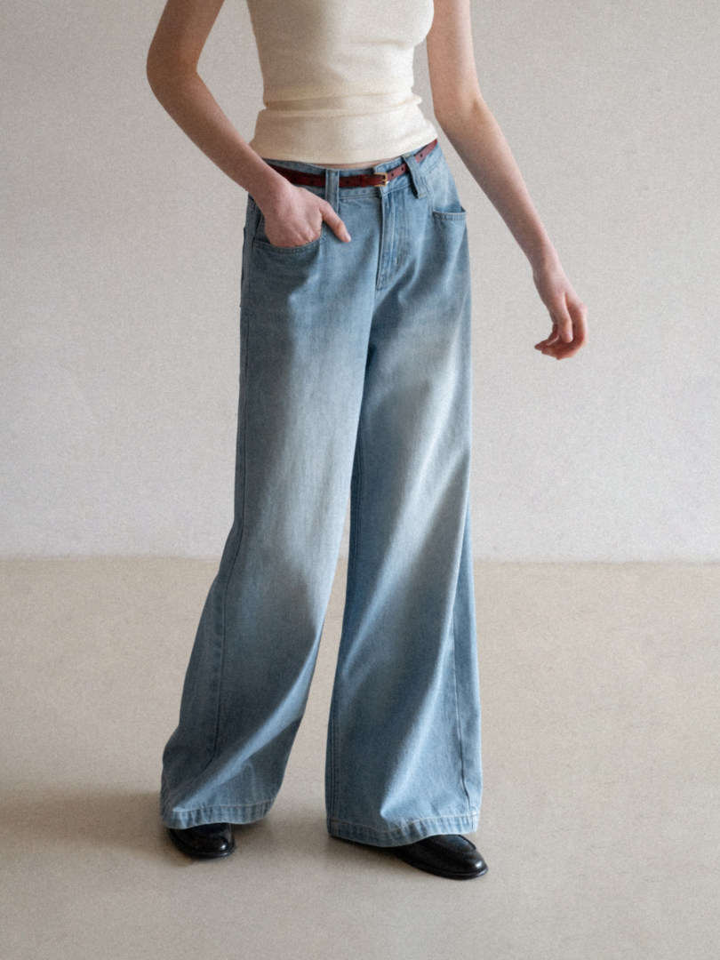 Light blue wide-leg jeans worn with a cream tank top and black shoes