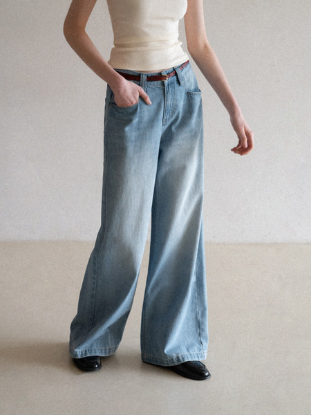 Light blue wide-leg jeans worn with a cream tank top and black shoes