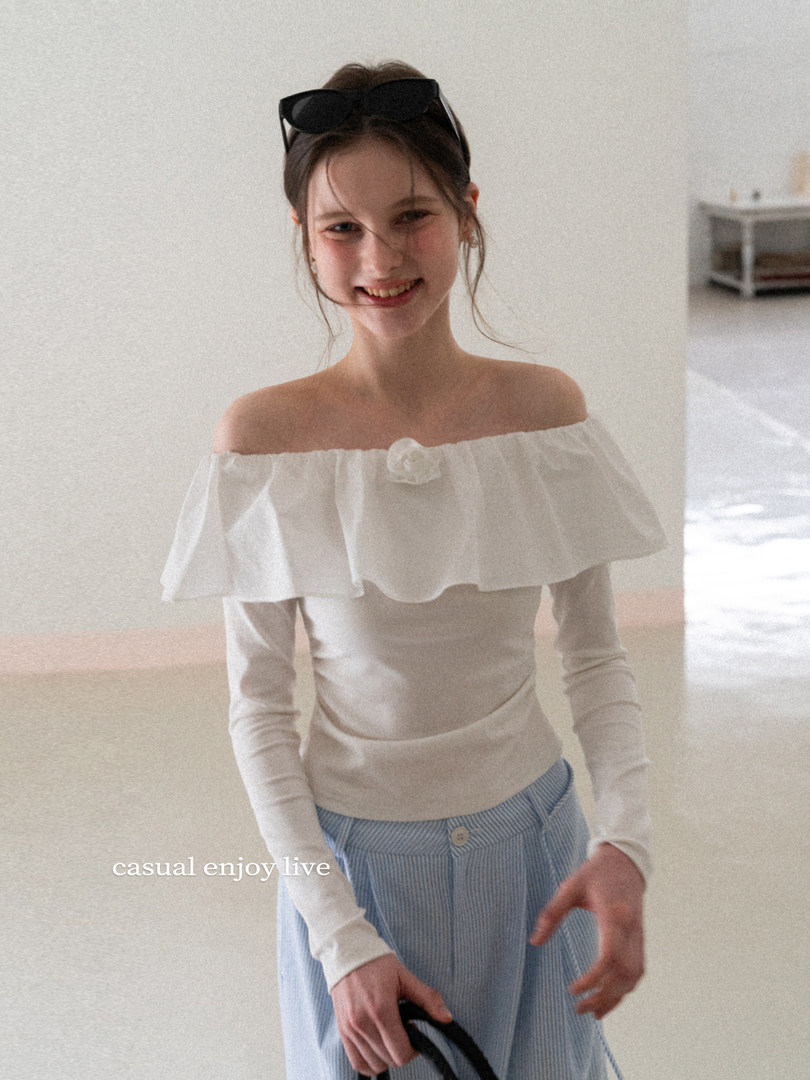 Woman wearing a white off-shoulder long-sleeve top with ruffle detail