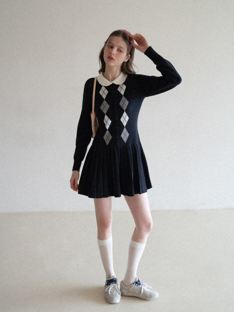 Model wearing a black long-sleeve argyle mini dress with a white collar