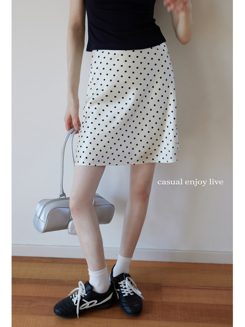 White polka dot mini skirt worn on a model with casual styling