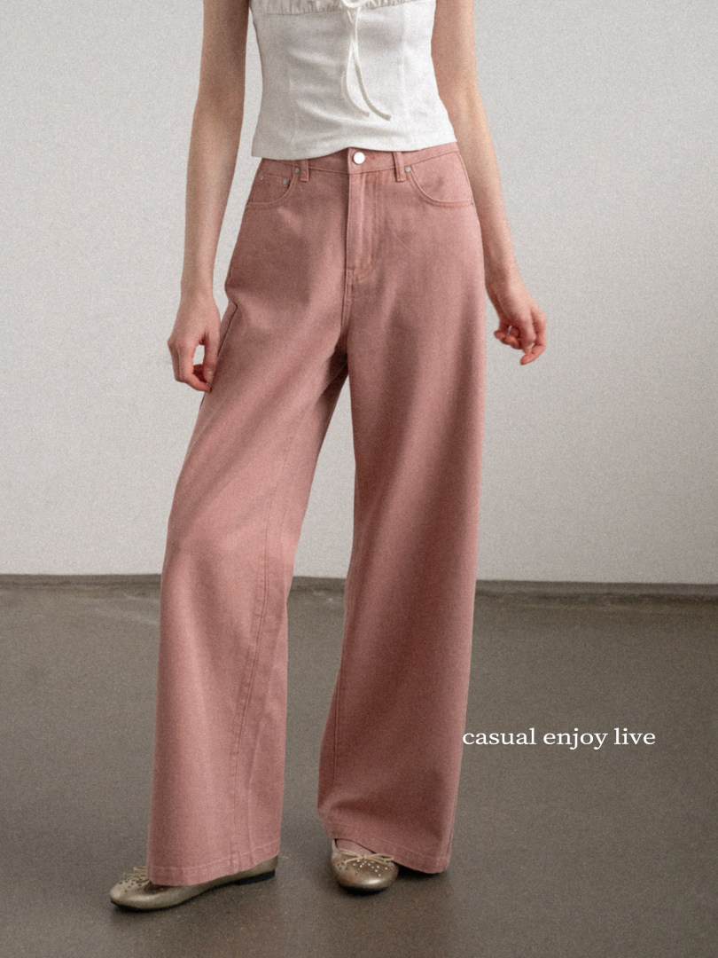 Model wearing wide-leg pink pants with a white sleeveless top