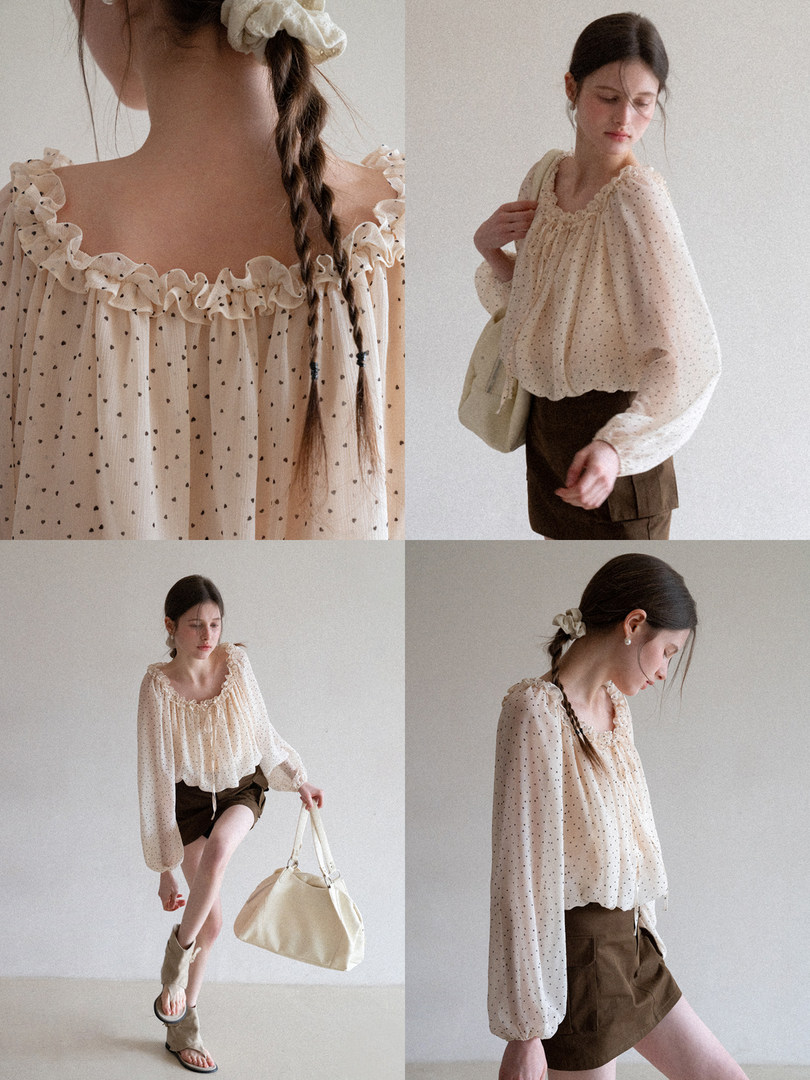 Sheer cream polka dot ruffled blouse worn by a model