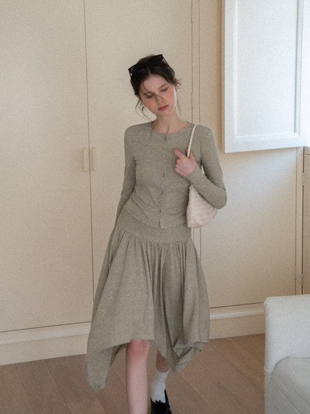 Woman modeling a light sage knit cardigan and matching skirt with a small shoulder bag