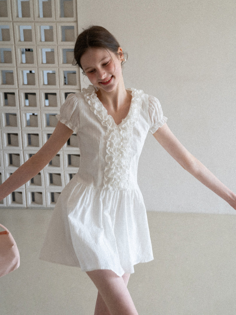 White short-sleeve ruffled dress worn by a model