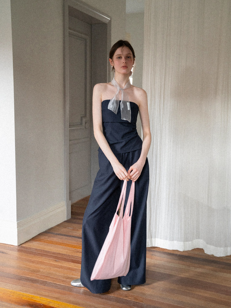 Navy strapless wide-leg outfit worn by a model indoors